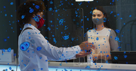Passing card across plexiglass divider, customer in red mask suspenders reaching, staff gray apron....