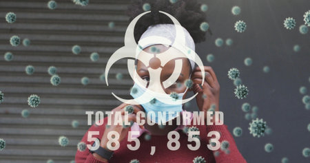 Holding phone and adjusting mask, woman in red sweater standing by shutter with biohazard 585,853....