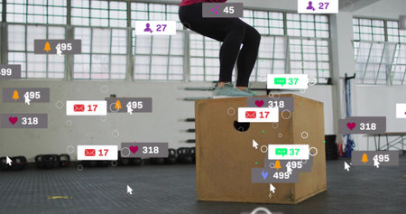 Balancing woman in leggings and teal shoes on wooden plyo box in gym with digital overlays. Fitness,...