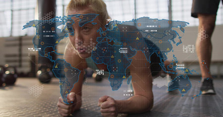 Holding forearm plank midadult woman wearing tank and shorts in gym with trainer, map overlay....