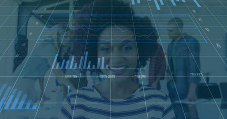 Smiling African American woman showing data overlay in office, with monitors, wearing striped shirt....