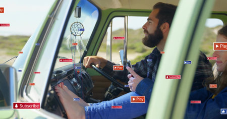 Driving man holding phone, passenger resting bare feet on dash in green van, shirts, UI overlays....