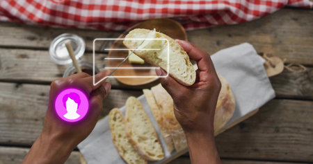 Spreading butter with knife, hands holding sliced bread at table with butter dish and purple avatar. Crusty, loaf, rustic, kitchen, cutting, board, linenの写真素材