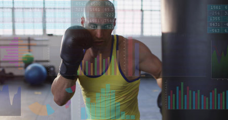 Punching boxer wearing yellow tank top and black gloves at gym with heavy bag, data overlay....