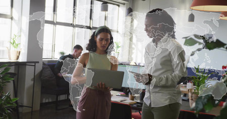 Discussing, coworkers in office wear pointing at laptop in open-plan office with world map overlay....