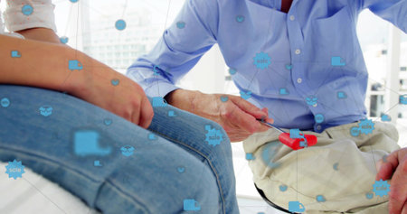 Holding red-handled tool, man teaching child in bright room, denim and light-blue shirt, blue icons....