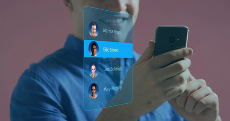 Smiling man wearing blue shirt holding dark phone in studio, viewing AR panel selecting Eric Brown. Augmented, interface, smartphone, avatar, holographic, pink, gradient