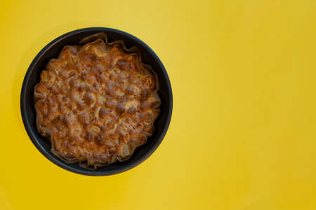 Cooked apple pie on a yellow background. Apple feast in a curly shape. Image for the menu of cafes,...