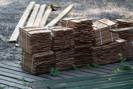 Bundles of wooden planks for construction at a construction site. Warehouse of a wooden picket fence...