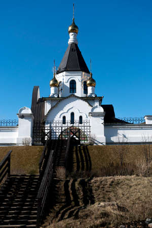 White temple with golden domes on the hill. Temple against the blue sky.の写真素材