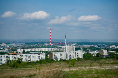 An industrial city on the horizon against the backdrop of a cloudy sky. A city with buildings under...