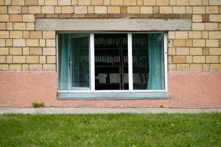Open window of the library on a summer day. Densely arranged folders with documents on the archives.