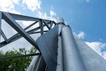 Mock up of a space rocket on a pedestal against the backdrop of a cloudy sky. Silver rocket with red nozzles. Rocket model near the Aerospace Institute.の写真素材