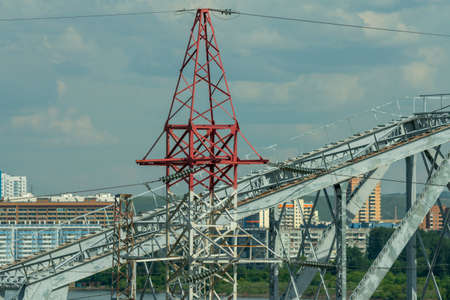 Electric pole against the background of the arch of the railway bridge. Power lines along railway...