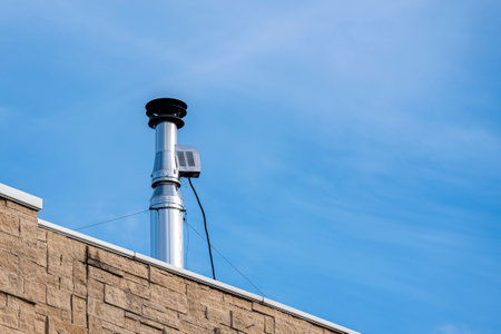 Shiny galvanized ventilation pipe on the roof of the building. Trumpet against the blue sky.の写真素材