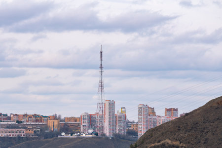 Residential high-rise buildings on top of a mountain across the river. Construction of a residential sleeping area on the outskirts of the city.の写真素材