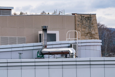 Shiny galvanized ventilation pipe on the roof of the building. Trumpet against the blue sky.の写真素材