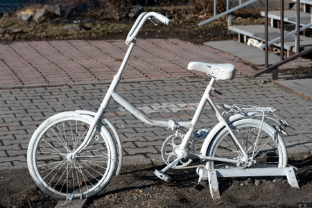 Bicycle painted with white paint on the lawn in the city. Art installation in the city.の写真素材