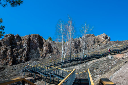 Metal stairs with wooden railings on the mountain. Staircase in the national park. Rocks behind the stairs on the mountain.の写真素材