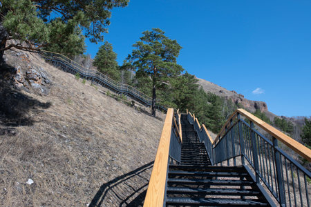 Metal stairs with wooden railings on the mountain. Staircase in the national park.