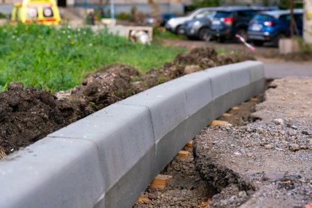 New concrete curbs installed on the side of the road. Repair work on the road surface in the city.の写真素材