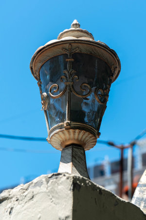 Street lamp with an antique lampshade against the blue sky. Street lighting.