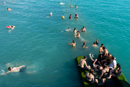 Sochi, Russia - July 05 2022: Children swim in the sea jumping from the breakwater. Children swimming in the sea.の写真素材
