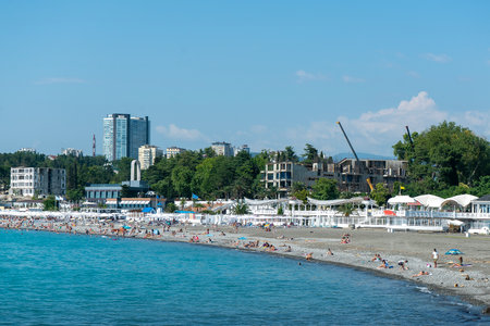 City beach in the sea bay of the resort town. Beach with vacationers by the sea.の写真素材