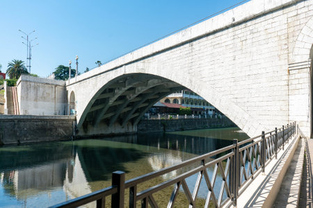 Arch of a stone bridge over the water of a water canal in the city. Architecture of a water canal in the city.の写真素材
