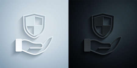 Paper cut Shield in hand icon isolated on grey and black background. Insurance concept. Guard sign. Security, safety, protection, privacy concept. Paper art style. Vectorのイラスト素材