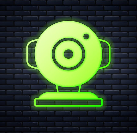 Glowing neon Web camera icon isolated on brick wall background. Chat camera. Webcam icon. Vectorのイラスト素材
