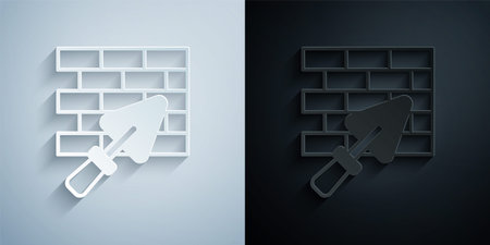 Paper cut Brick wall with trowel icon isolated on grey and black background. Paper art style. Vectorのイラスト素材