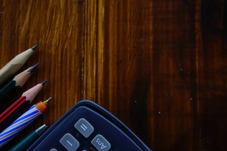 School supplies on wooden background with copy space. Calculator, pencils and pens. advertising back to schoolの写真素材