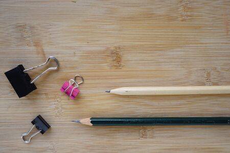 Binder Paper clip and pencils on wooden background. copy space for text rustic concept