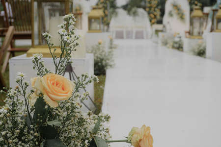yellow rose and white flower on wedding floral decorations set. elegant outdoor white wedding conceptの写真素材