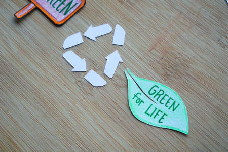 Phrase of Earth day. Saving our earth, go green, recycle symbol concept background on wooden board