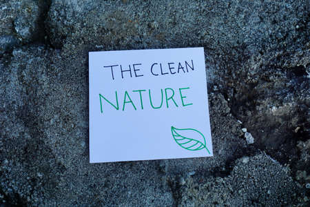 hand holding Climate change Text concept with rock background. Ready Text for environment earth day concept. Text on white paper with backgroundの写真素材