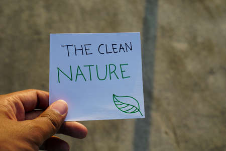 hand holding Climate change Text concept with rock background. Ready Text for environment earth day concept. Text on white paper with backgroundの写真素材