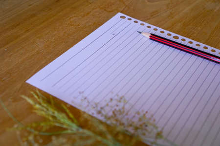 dry wild grass flower on wooden background and stationery blank paper. copy space for greeting...