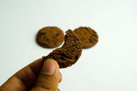 chocolate cookies and dark chocolate grain on wooden board background. for text concept advertising