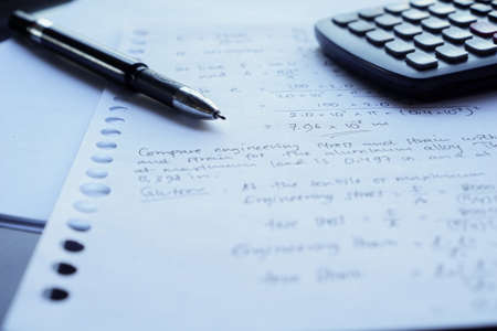 scientific math workout. sheet paper with solving equation math next to calculatorの写真素材