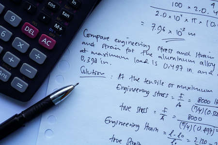 scientific math workout. sheet paper with solving equation math next to calculator