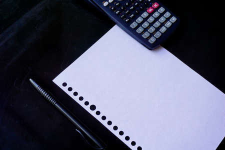 blank paper, ballpoint, and calculator for mockup concept on wooden board. finance, education...
