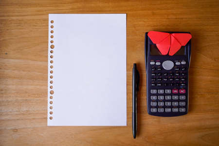 blank paper, ballpoint, and calculator for mockup concept on wooden board. finance, education backgroundの写真素材