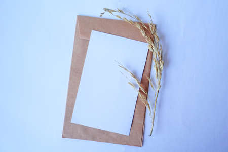 Brown envelope and white letter with dried grass for mockup greeting seasonal conceptsの写真素材