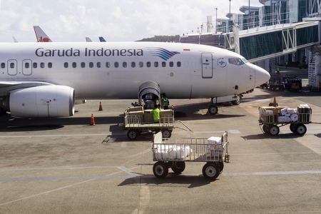 BALIKPAPAN, INDONESIA - AUGUST 02, 2017 : Ground staff loading pasangger baggage and cargo to Garuda...
