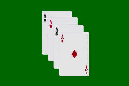 Four aces isolated on green background.