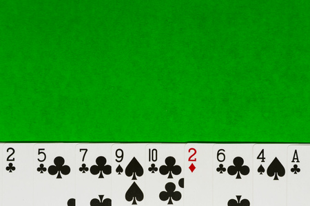 Playing or poker cards on green background with copy space.