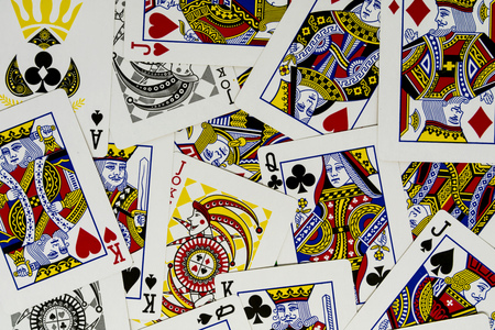 JAKARTA, INDONESIA - AUGUST 14, 2017 :  Messy playing or poker cards with king, queen, jack, and joker on the green background. scattered cards deck.のeditorial素材