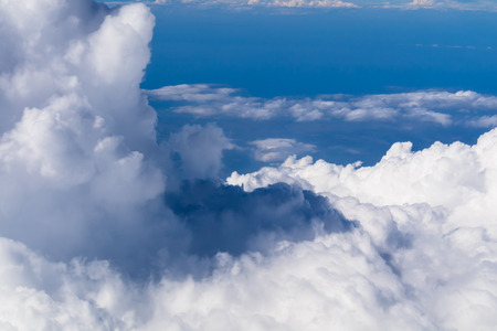 aerial view from the window of an airplane flying above the clouds with beautiful blue sky in summer...